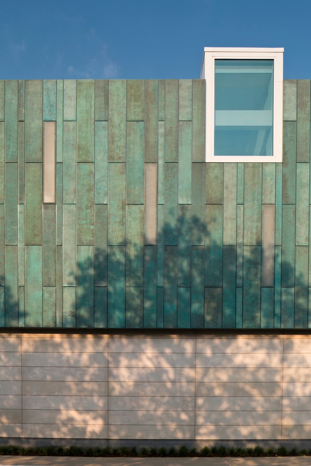 Blue-green verdigris copper panels on a building facade